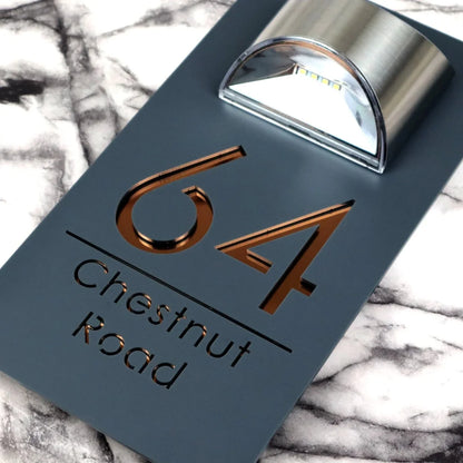 Close-up of copper mirrored lettering on the matt grey luxury solar LED house sign